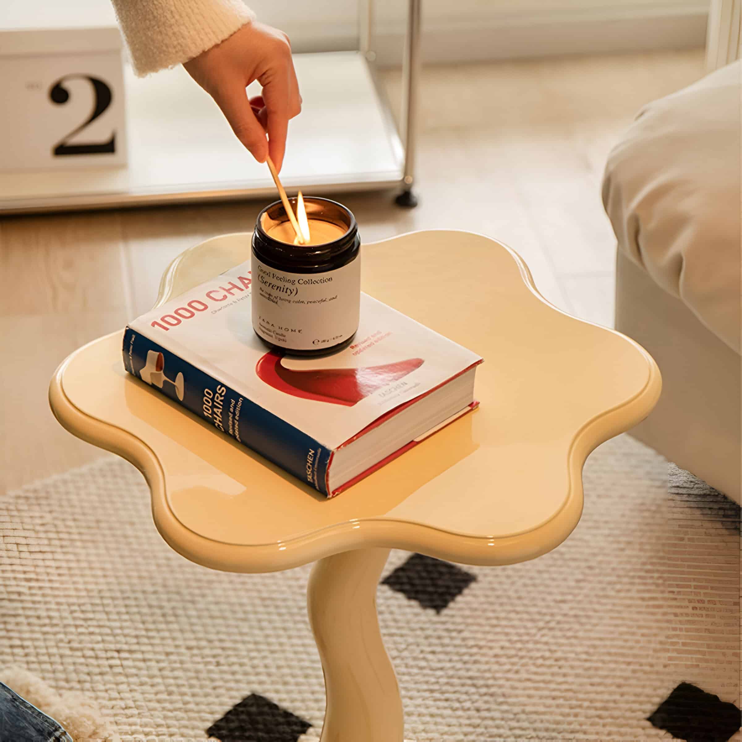 Bright candle on decorative cream-colored side table with elegant curves, ideal for relaxation and creating a calming atmosphere in a contemporary bedroom.