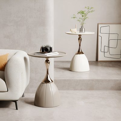 Stylish modern side tables with unique bases in a minimalist living room setup, featuring decorative objects, a sofa, and elegant artwork for a chic and inviting ambiance.