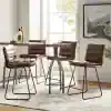 Elegant leather dining chairs with metal legs around a modern table, ideal for stylish kitchens or cafes, featuring natural light and contemporary decor.