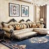 Luxurious antique-style cream and black upholstered sofa with ornate carved wood details, complemented by decorative pillows, modern artwork, and a chandelier in a sophisticated interior setting.