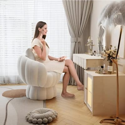 Woman applying face makeup at modern beauty vanity with skincare products and mirror in elegant skincare salon setting.