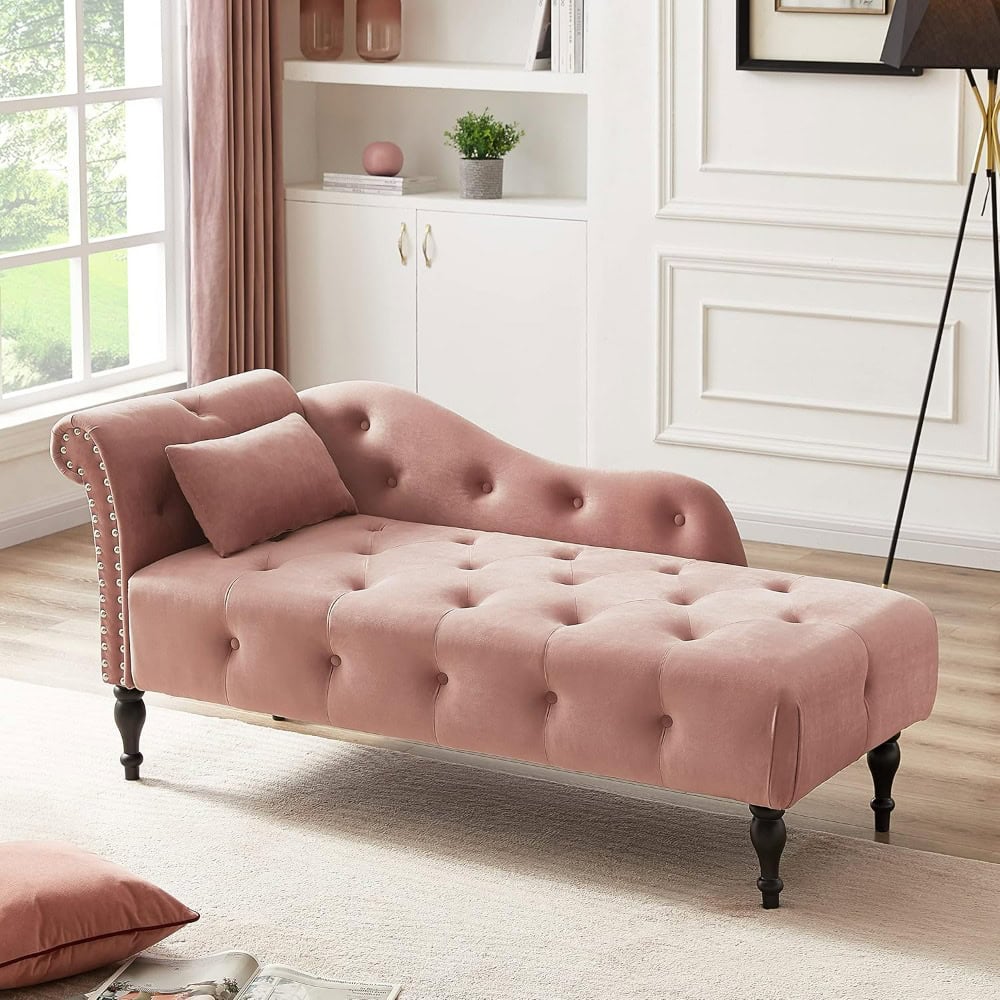 Luxurious pink velvet chaise lounge with tufted design and elegant black wooden legs, perfect for modern living rooms and upscale spaces.
