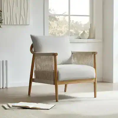 A modern white armchair with a wooden frame and woven rattan sides, perfect for stylish home or office decor. Bright natural light enhances the cozy and contemporary atmosphere.