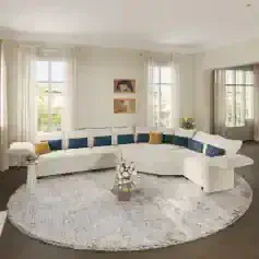 Bright living room with large windows, white curtains, and colorful accent pillows.