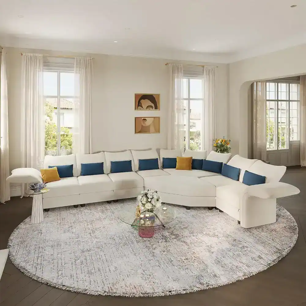 Bright living room with large windows, white curtains, and colorful accent pillows.