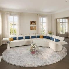 Bright, modern living room with spacious white sectional sofa, decorative cushions, and elegant decor, perfect for comfort and style in a sophisticated home setting.
