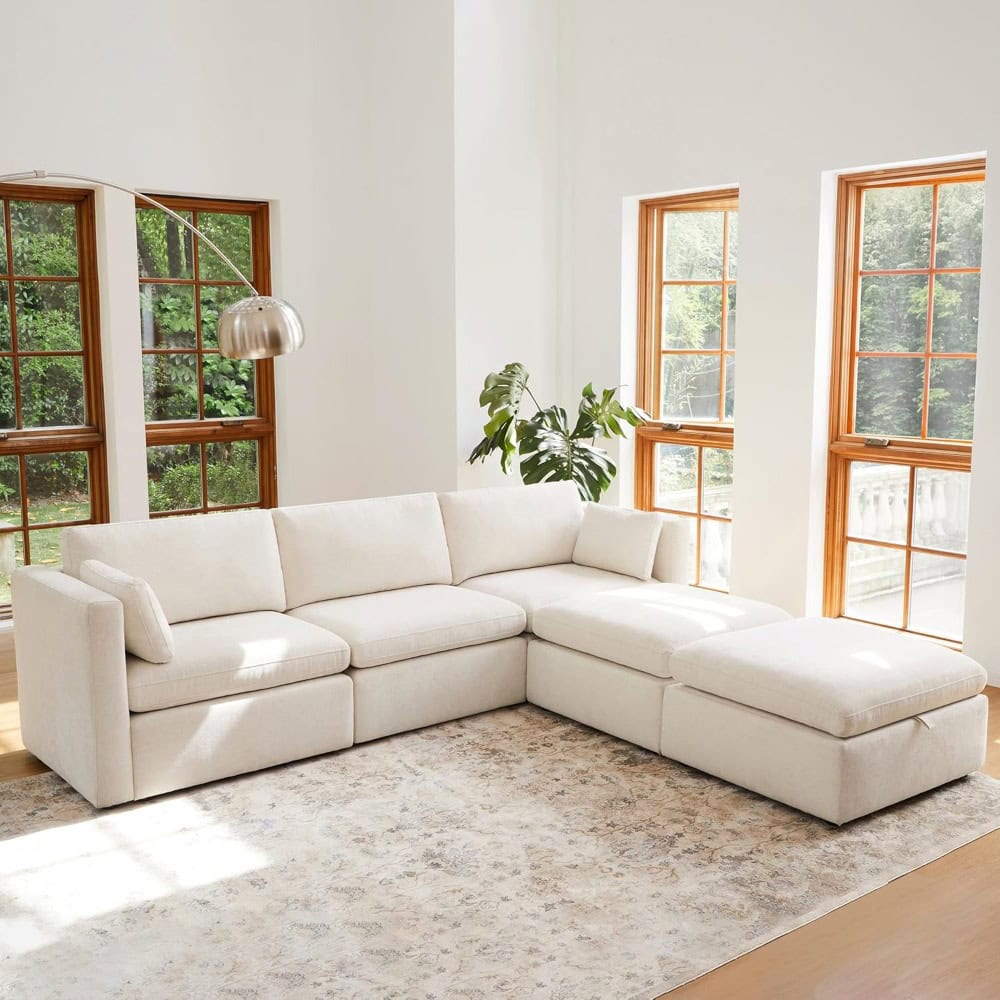 Bright living room with white sectional sofa, natural light, and wooden window frames, creating a cozy and inviting space for relaxation and social gatherings.
