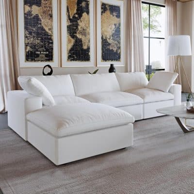 Spacious white velvet sectional sofa in a contemporary living room with large windows, neutral curtains, and minimalist decor, perfect for stylish home relaxation.
