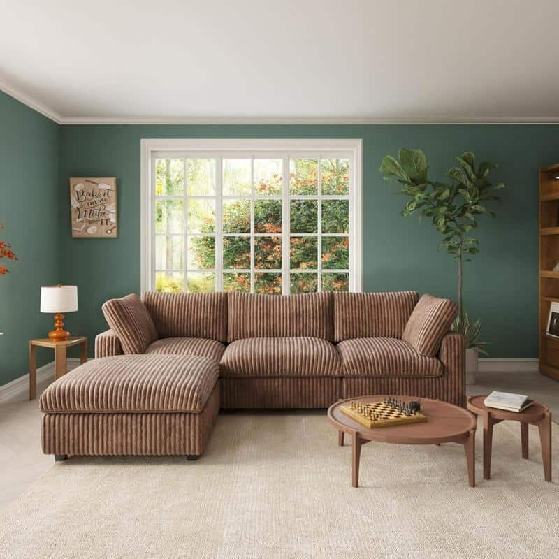 Cozy living room featuring a striped brown sofa, large window, potted plant, side table with lamp, and a bookshelf, creating an inviting space for relaxation and social gatherings.