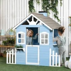 Playhouse for kids, blue wooden playhouse with two children playing, outdoor toy playhouse, kids in a backyard playing, children's outdoor play area with garden decor.