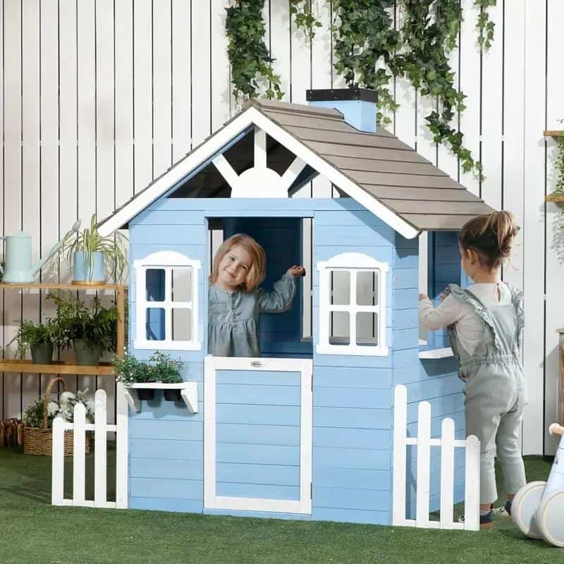 Playhouse for kids, blue wooden playhouse with two children playing, outdoor toy playhouse, kids in a backyard playing, children's outdoor play area with garden decor.