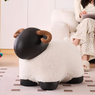 Fluffy sheep-shaped plush ottoman with black leather head and curved horns, perfect for cozy living rooms and nursery decor.