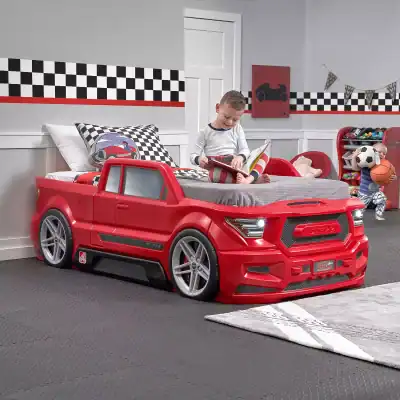 Red race car bed designed for kids Bedroom decor with racing theme, perfect for children who love cars and sports. Kids playroom furniture featuring a fun and sporty design.
