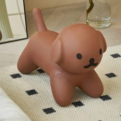 Soft pink dog-shaped storage container or decorative item, designed for home organization or playful decor, with cute facial features and a rounded body. Perfect for adding a touch of fun to any space.