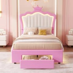 Pink children's bed with illuminated crown-themed headboard and storage drawer, pastel bedroom decor, ideal for a playful and cozy kids' bedroom.