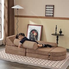 Comfortable sectional sofa with a neutral beige fabric in a modern living room setting. Perfect for relaxing or reading, complemented by stylish decor and natural light.