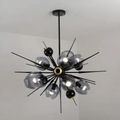Black modern chandelier with multiple glass globes and metal rods for stylish interior lighting.