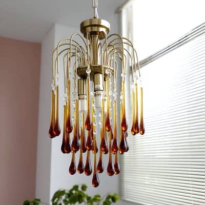 Elegant vintage-style chandelier with amber teardrop glass accents and crystal embellishments, enhancing interior lighting and decor for sophisticated home or office spaces.