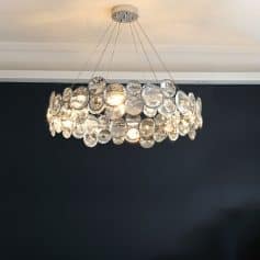 Elegant crystal chandelier hanging from ceiling, modern lighting fixture with glass orbs, stylish decor for luxury interior design, ideal for living rooms or dining spaces, enhances aesthetic appeal.