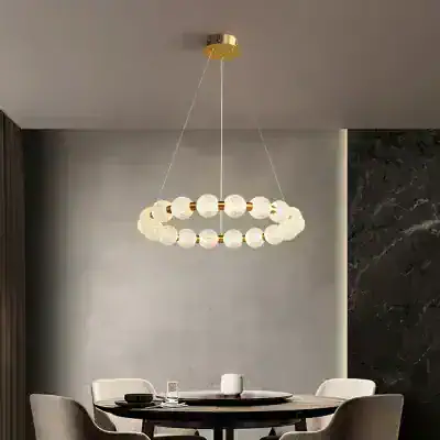 Elegant modern chandelier with spherical glass and gold accents hanging above a contemporary dining table. Perfect for sophisticated interior lighting in home or restaurant settings.
