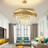 Elegant modern living room with grand chandelier and large windows, emphasizing luxury interior design, cozy seating, vibrant cushions, and natural light for a stylish home decor.