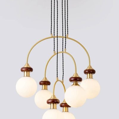 Modern gold and wood chandelier with multiple frosted glass globe lights, ideal for stylish interior lighting and home decor.