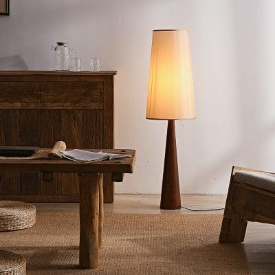 Cozy interior with wooden furniture, a warm standing lamp, and a minimalist decor setup for a comfortable living space.
