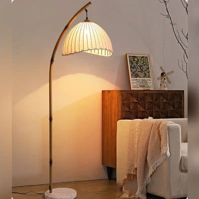 Elegant modern floor lamp with a curved wooden stand and beige fabric shade in a cozy living room.