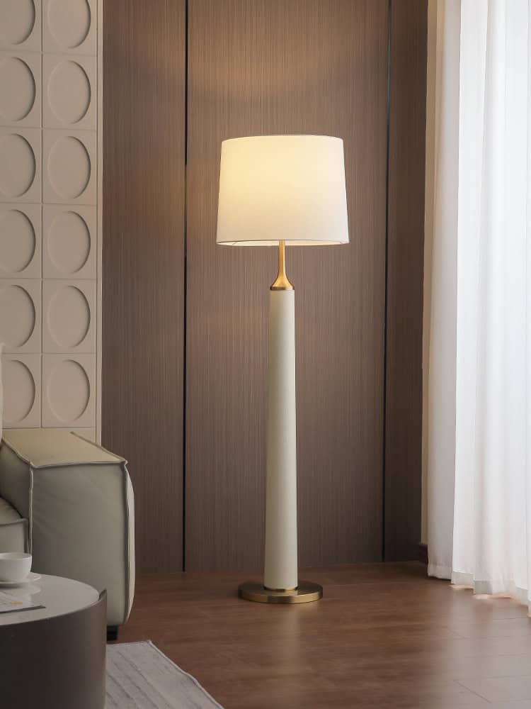 Elegant modern floor lamp with white shade in stylish living room setting.