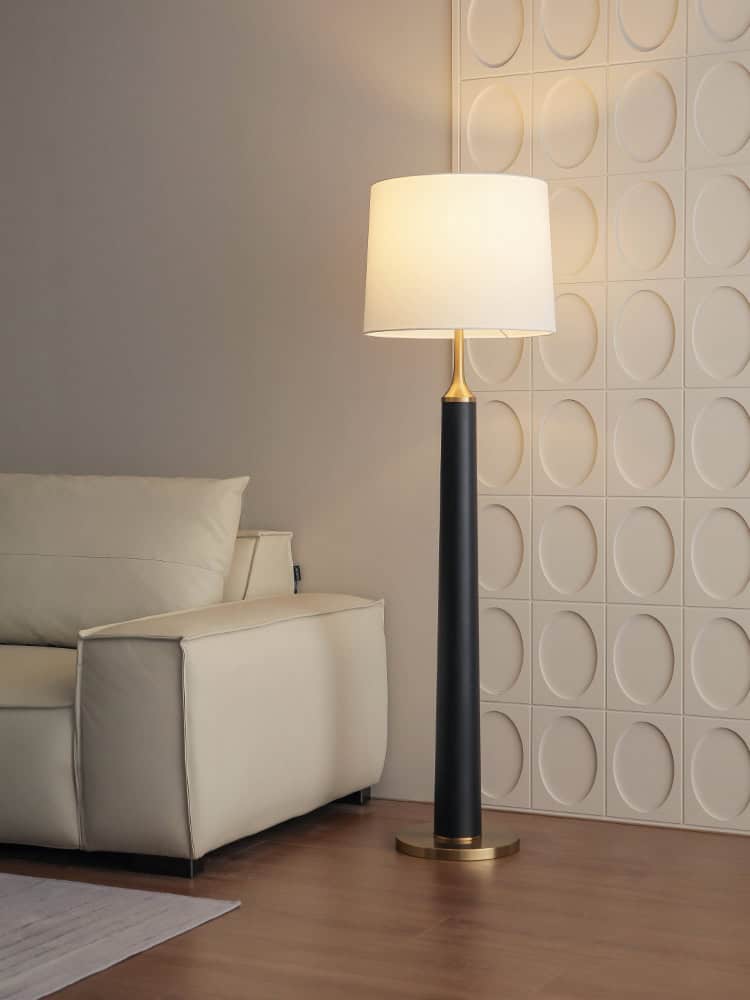 Stylish modern floor lamp with beige shade and black-gold finish, ideal for enhancing interior decor in living rooms or optical clinics.