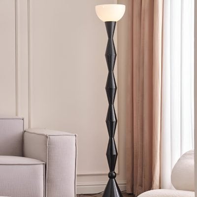 Modern black floor lamp with unique geometric design in a stylish living room setting.