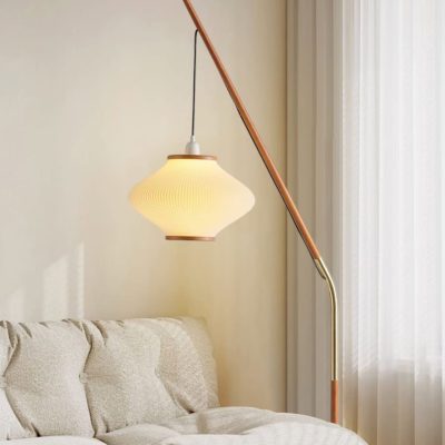 Elegant modern floor lamp with a warm glowing lampshade, standing beside a cozy beige sofa in a contemporary living room setting, ideal for stylish home decor and lighting solutions.
