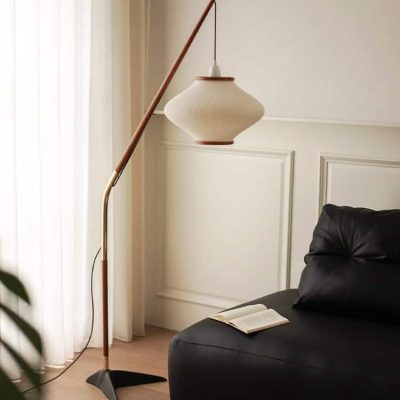 Modern floor lamp with a white pendant shade in a stylish, minimalist living room setting.