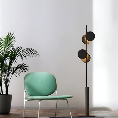 Modern minimalist seating area at Monalisa Medical Store with a green chair, black and gold contemporary floor lamp, and a decorative plant, emphasizing a clean and stylish ambiance for eye care and optical services.
