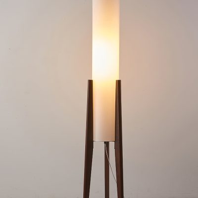 Elegant modern floor lamp with wooden tripod stand and fabric shade, ideal for living room or bedroom decor, providing warm ambient lighting for a stylish interior.