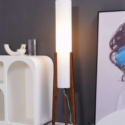 Modern floor lamp with wooden legs and white cylindrical shade, ideal for enhancing the ambiance of an optometry or optical store environment.