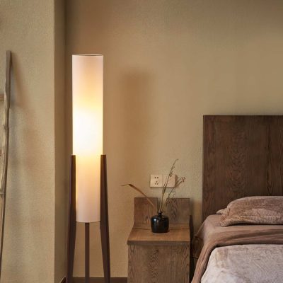 Elegant bedroom with a warm ambient light from a tall, modern floor lamp and cozy wooden furnishings, perfect for relaxation at Monalisa Store.