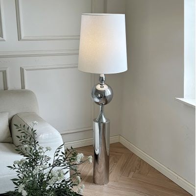 Luxury modern floor lamp with chrome finish and white lampshade in contemporary living room setting.