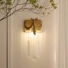 Elegant gold wall sconce with crystal beads and ornate drapery, perfect for upscale interior decor and enhancing ambient lighting in luxury homes or boutique interiors.