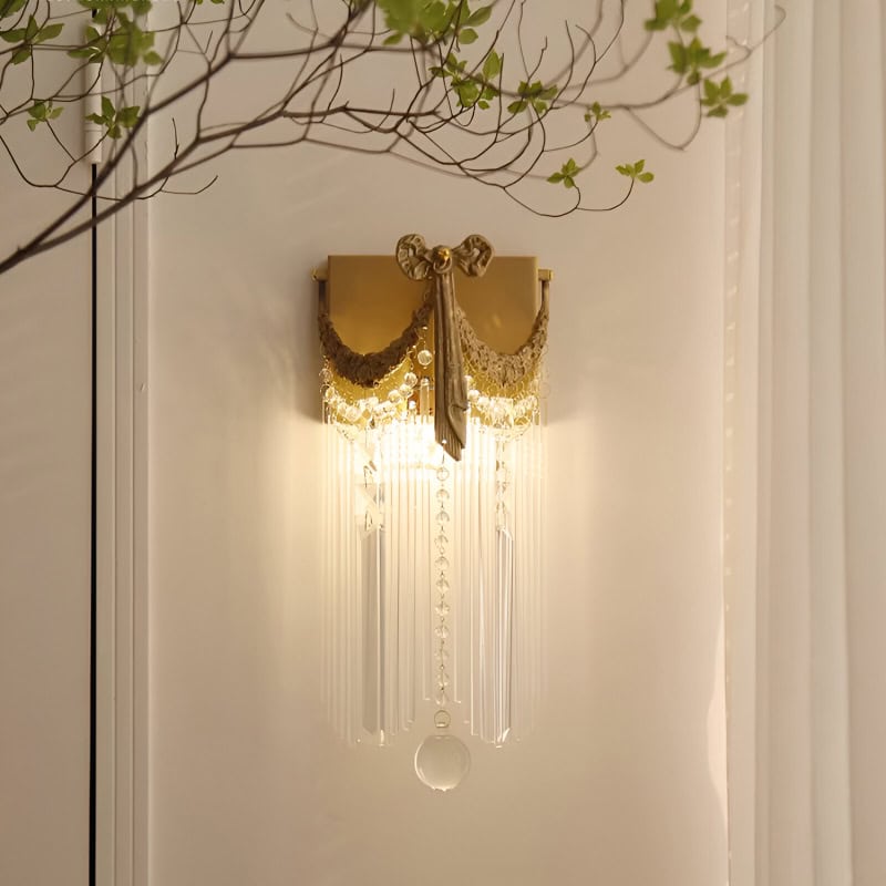 Elegant gold wall sconce with crystal beads and ornate drapery, perfect for upscale interior decor and enhancing ambient lighting in luxury homes or boutique interiors.