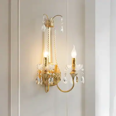 Elegant gold and crystal wall sconce chandelier with two candle-style lights and decorative hanging crystals, perfect for luxury home decor and upscale interior lighting.