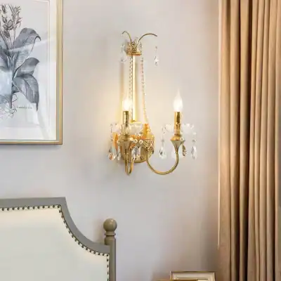 Elegant gold and crystal wall sconce in a luxurious bedroom setting, featuring ornate design and ambient lighting, perfect for upscale home decor and interior lighting.