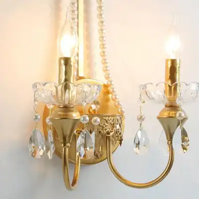 Elegant gold and crystal wall sconce chandelier with dangling pearls and gemstones, perfect for luxurious interior decor. Ideal for enhancing your living room, dining area, or bedroom ambiance.