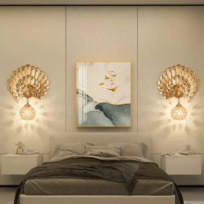 Gold peacock wall sconces with marble art piece above bed, modern luxury bedroom decor.
