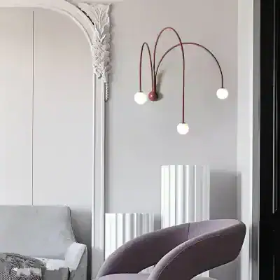 Modern minimalist interior decor featuring a contemporary wall-mounted light fixture with three white globe bulbs and elegant furniture in a stylish opt clinic or store setting, emphasizing modern design.