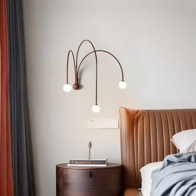Sleek modern bedroom wall light fixture with three curved arms and round bulbs, stylish and functional, ideal for contemporary interior decor.