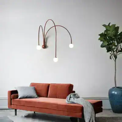 Modern wall-mounted light fixture with spherical bulbs and curved arms, blending contemporary style with functional lighting in a sleek living room setup.