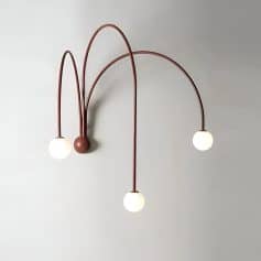 Modern stylish wall light fixture with three spherical bulbs and curved metal arms, ideal for interior lighting in homes or medical clinics, enhancing aesthetic appeal.