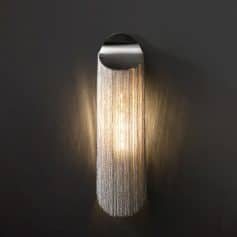Stylish modern wall sconce with metallic chain curtain design for elegant interior lighting enhances room decor and ambiance.