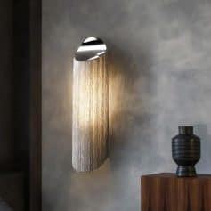 Luxury modern wall light with metallic chain design, decorative interior lighting fixture for home or office decor.